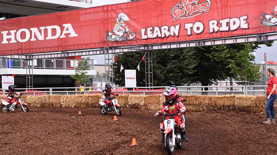 Honda Junior Red Riders race around the dirt track at the Honda Indy Toronto